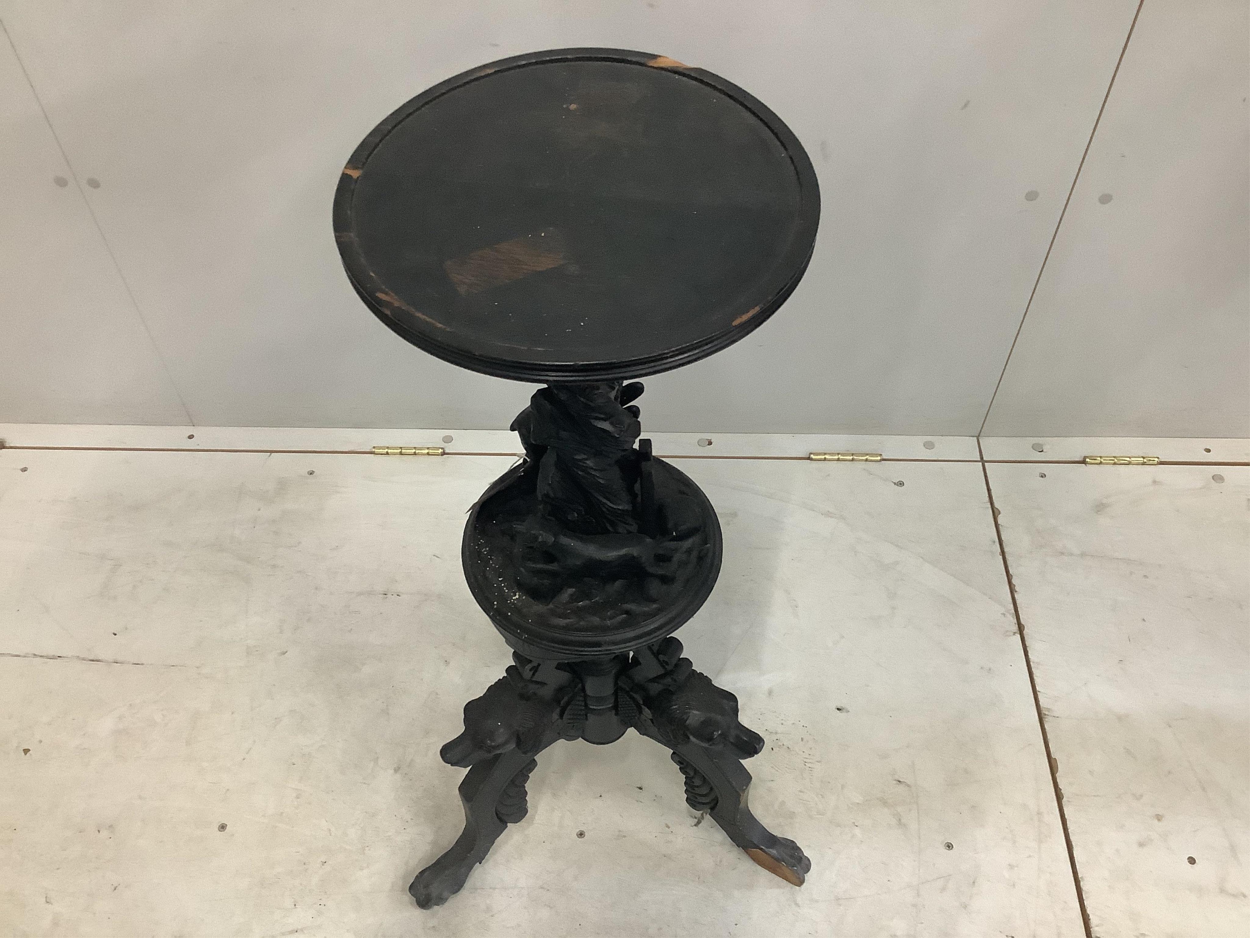 A late 19th century Black Forest ebonised wood urn stand carved with a running deer and hounds heads, height 90cm. Condition - poor, numerous losses